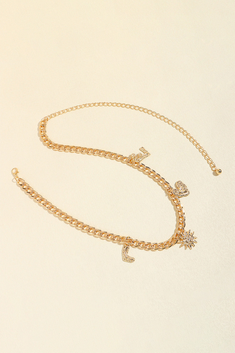 Gold chain belt with celestial charms including a sun, moon, and heart.
