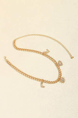 Gold chain belt with celestial charms including a sun, moon, and heart.