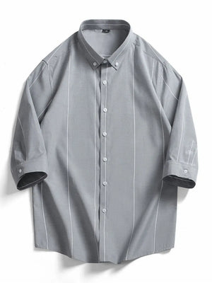 Grey cotton oversized button-down shirt with white vertical stripes and buttoned cuffs.