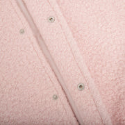 Blush pink textured bouclé bomber jacket with rounded neck and snap closures.