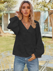 Black textured puff sleeve v-neck blouse with voluminous sleeves.