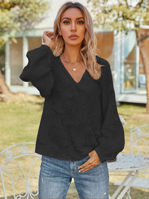 Black textured puff sleeve v-neck blouse with voluminous sleeves.