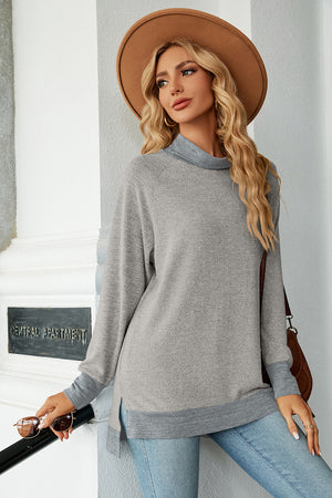 Colorblock raglan turtleneck tunic in light gray with darker gray trim and side slits.