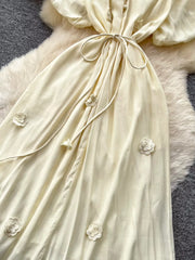 Apricot floral maxi dress with puff sleeves and tie waist, featuring 3D floral appliques.