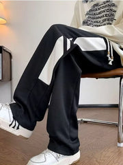 Black relaxed fit men's sweatpants with white contrast stripes and drawstring.