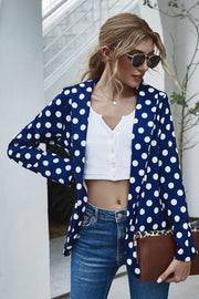 Dark blue polka dot open-front blazer with long sleeves, styled with a white crop top and jeans.