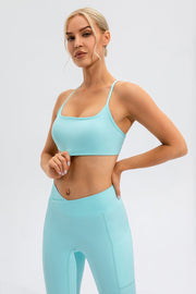 Aqua sports bra with thin straps and square neckline, paired with matching leggings.