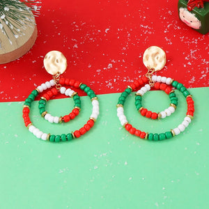 Festive beaded hoop earrings in red, white, and green with gold accents.