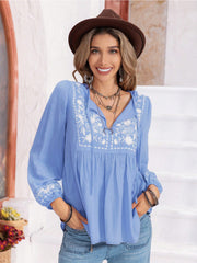 Misty Blue embroidered yoke blouse with gathered bodice, tie neck, and voluminous sleeves.