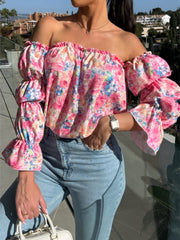 Off-the-shoulder blouse with ruffle sleeves in a floral print, featuring a smocked neckline.