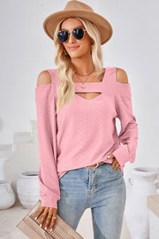 Blush pink long sleeve blouse with geometric cutout shoulder and neckline detail.