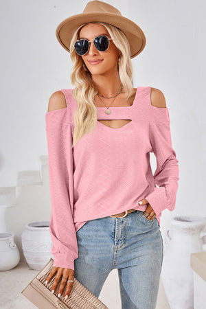 Blush pink long sleeve blouse with geometric cutout shoulder and neckline detail.