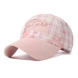 Blush pink plaid baseball cap with embroidered text and cotton fabric.
