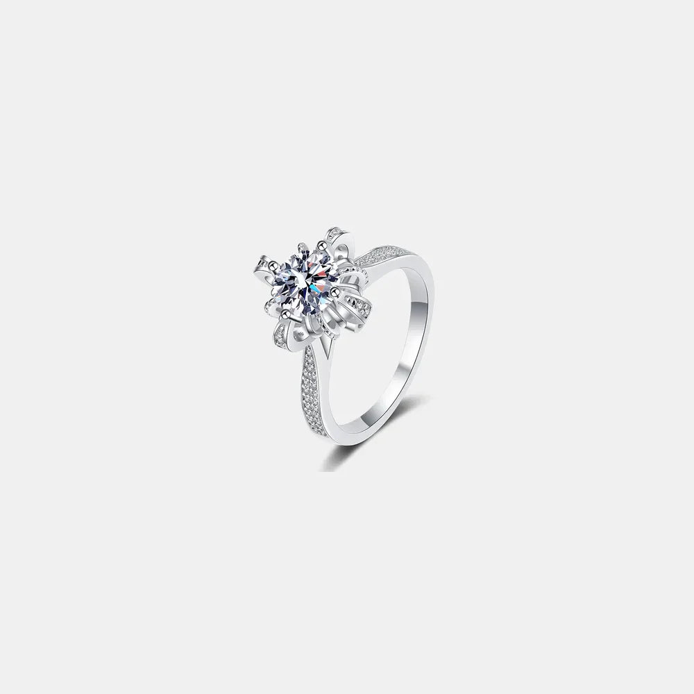 Sterling silver ring with a round-cut diamond in a floral setting and pave band.
