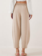Tan balloon trousers with sculpted seamlines and elastic waistband, cropped length
