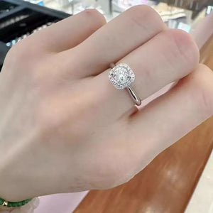 Elegant moissanite and sterling silver ring with cushion-cut center stone and halo.