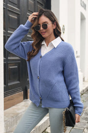 Blue chunky knit button-through cardigan with V-neck and front pockets.