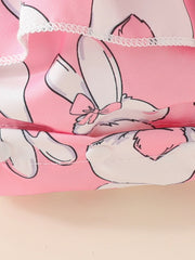 Pink baby dress with bunny print and ruffled trim, matching headband detail.