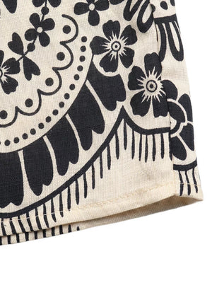 Bohemian-inspired wide leg maternity pants in beige with a black boho floral print and pockets.