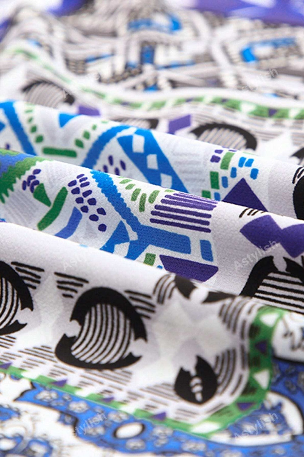 Patchwork print duster shirt jacket with blue, green, and purple geometric patterns on white fabric.