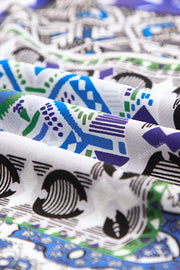 Patchwork print duster shirt jacket with blue, green, and purple geometric patterns on white fabric.