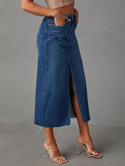 Denim midi skirt in dark wash with a raw-edge hem and high slit.