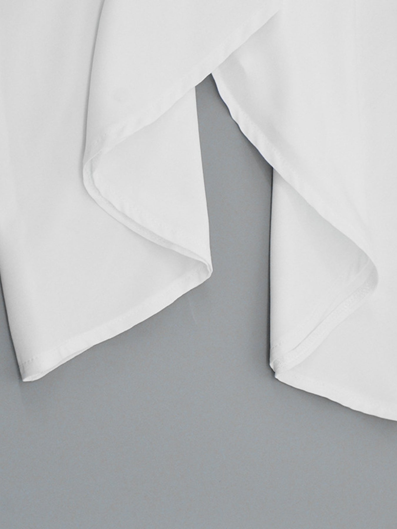 White flowy maxi dress with draped fabric detail and wide straps.