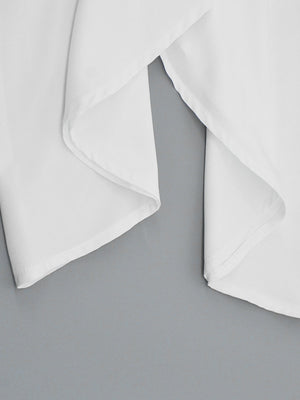 White flowy maxi dress with draped fabric detail and wide straps.