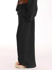 Black relaxed wide-leg maternity pants with drawstring waist and pockets.