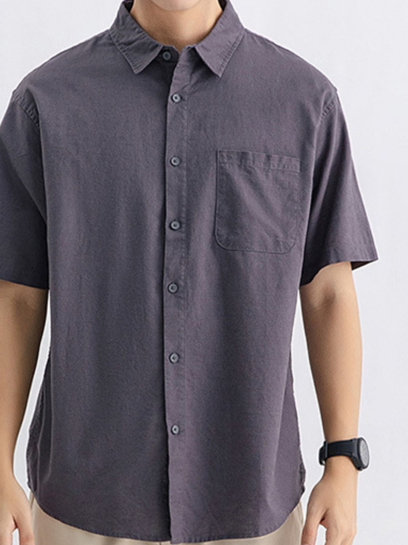Men's short sleeve buttoned shirt in dark gray cotton with chest pocket.