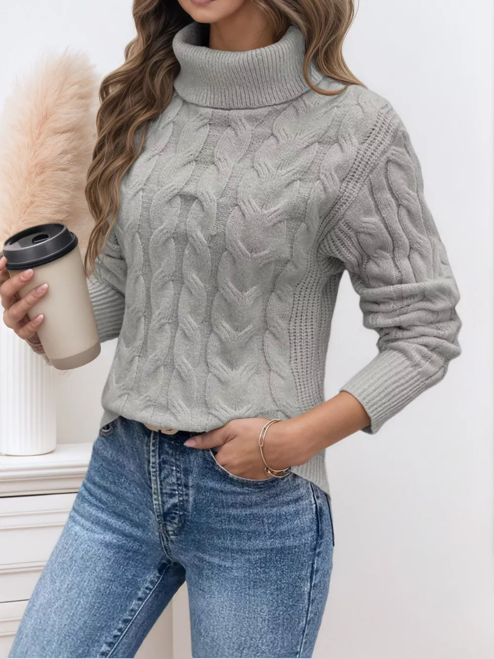 Grey cable-knit turtleneck sweater with a cozy texture and relaxed fit.