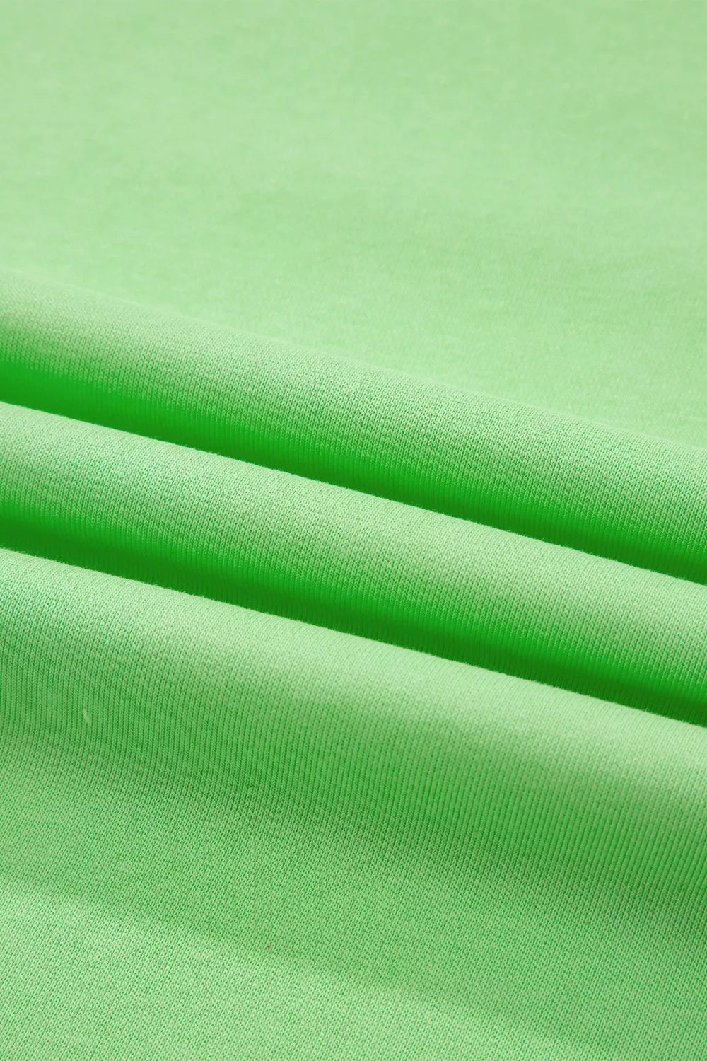 Green cotton two-piece set with pants, showing fabric texture and folds.