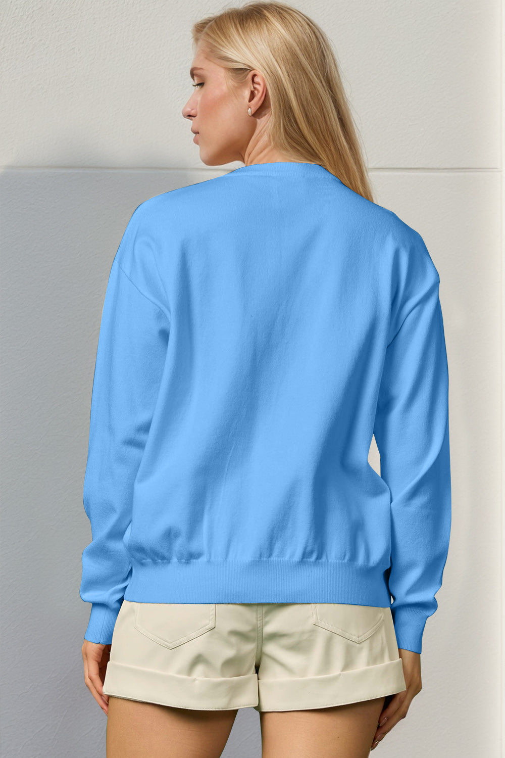 Sky blue crewneck sweater, 100% polyester knit, with long sleeves and ribbed cuffs and hem.