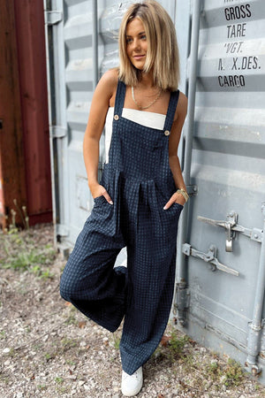 Dark blue textured wide-leg overalls with button detail and pleats