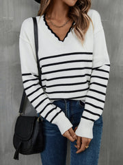 White and black striped knit sweater with scalloped trim V-neck and long sleeves.