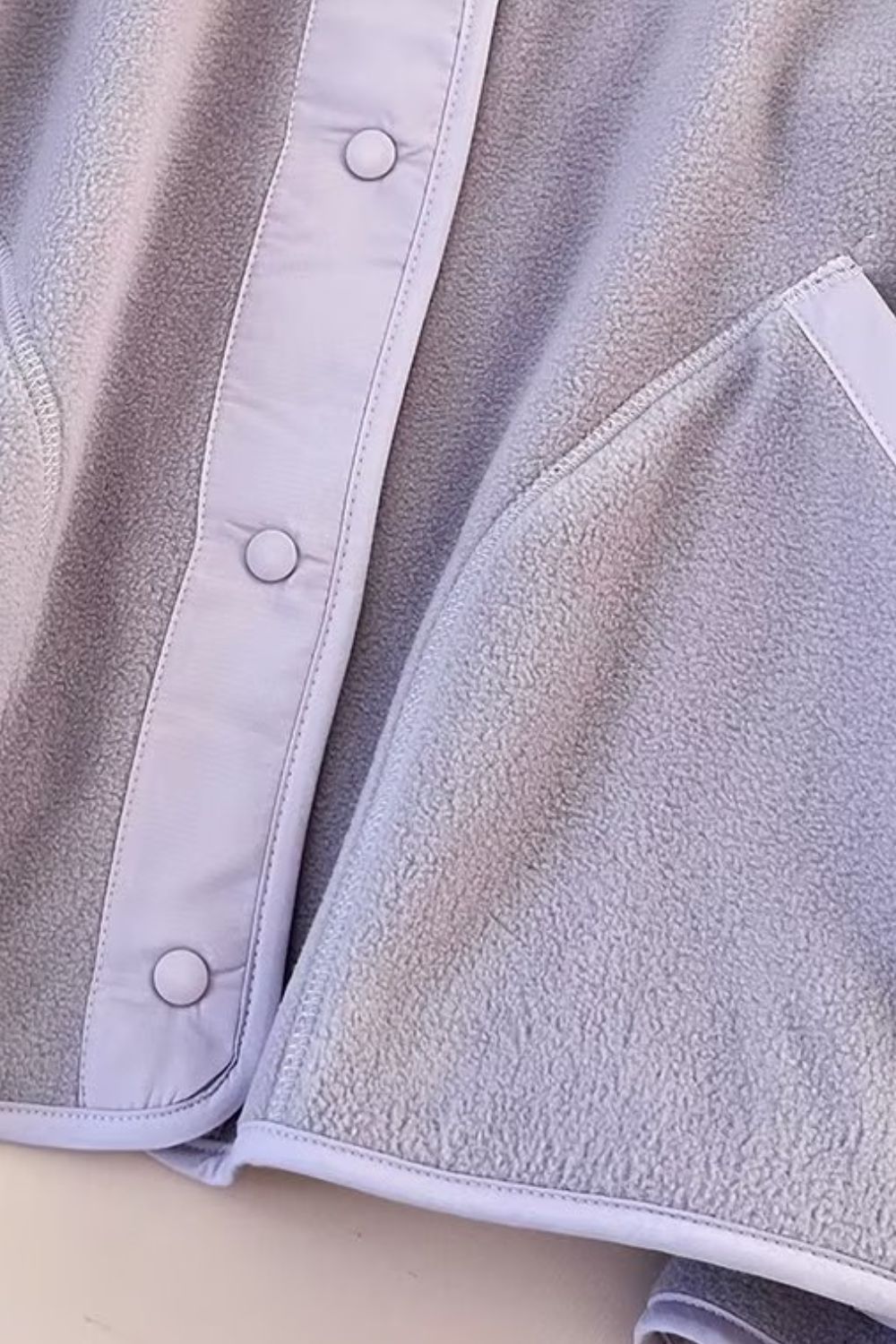 Light Gray fleece bomber jacket with contrast trim and snap buttons.