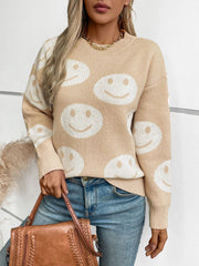 Tan knit sweater with allover white smiley face intarsia pattern, crew neck, long sleeves.