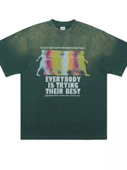 Green acid wash graphic t-shirt with multicolor figures and text print.
