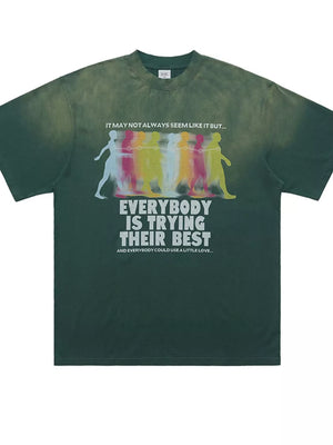 Green acid wash graphic t-shirt with multicolor figures and text print.