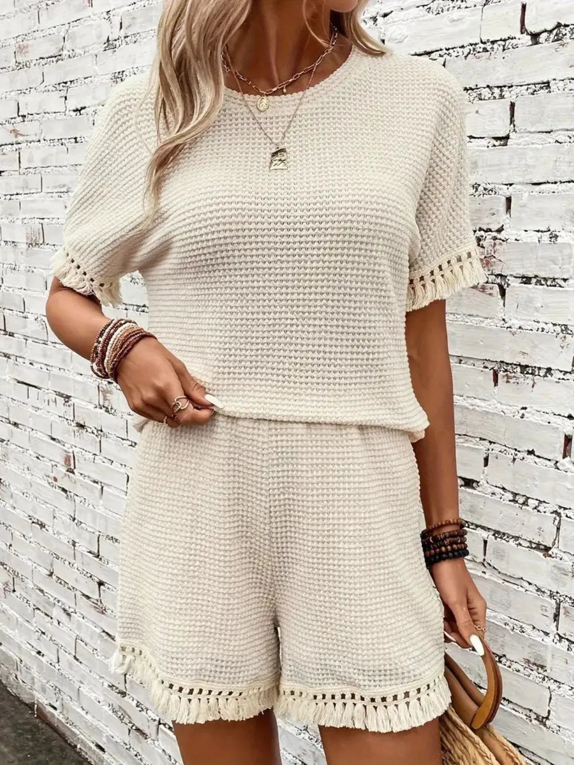 Cream textured knit outfit set with fringe detail on short sleeves and hem.