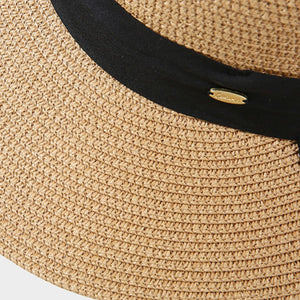 Woven straw sun hat in beige with black band and gold detail.