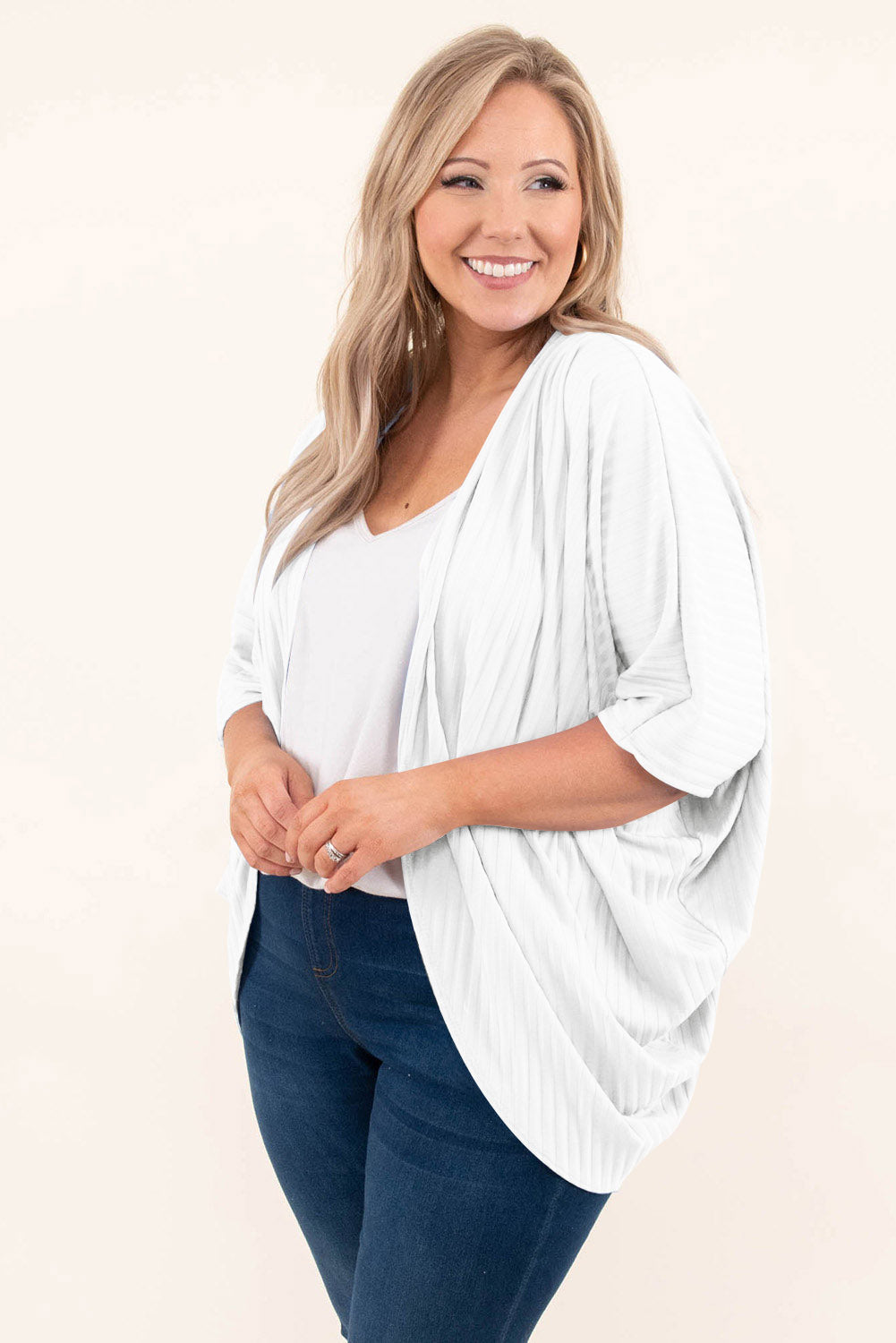 White ribbed batwing cardigan with drape front and dolman sleeves, styled with a white top and jeans.
