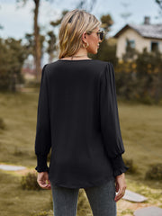 Black peplum sleeve blouse with gathered yoke and smocked cuffs.