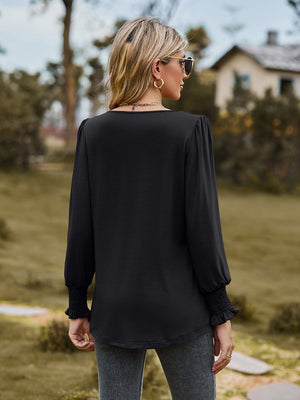 Black peplum sleeve blouse with gathered yoke and smocked cuffs.