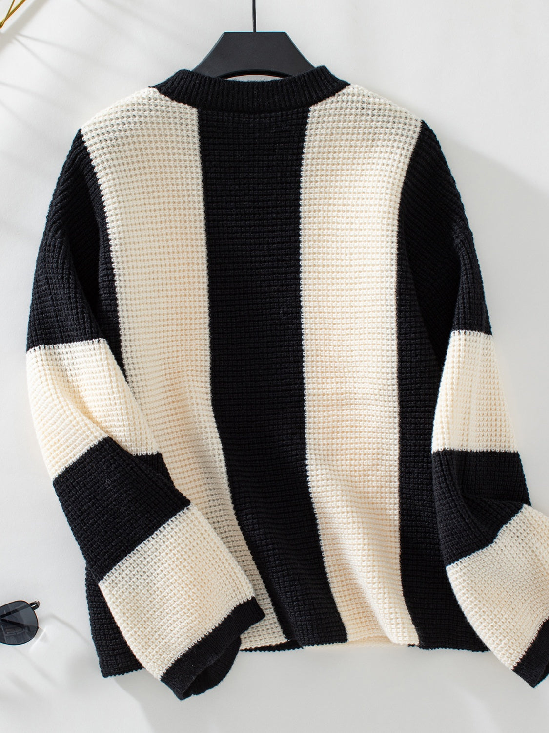 Colorblock stripe knit sweater with waffle texture in black and cream.