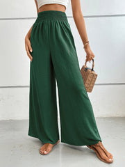Textured palazzo lounge trousers in dark green with a smocked waist and wide legs.