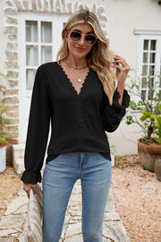 Black eyelet lace blouse with V-neck and ruffle sleeves.