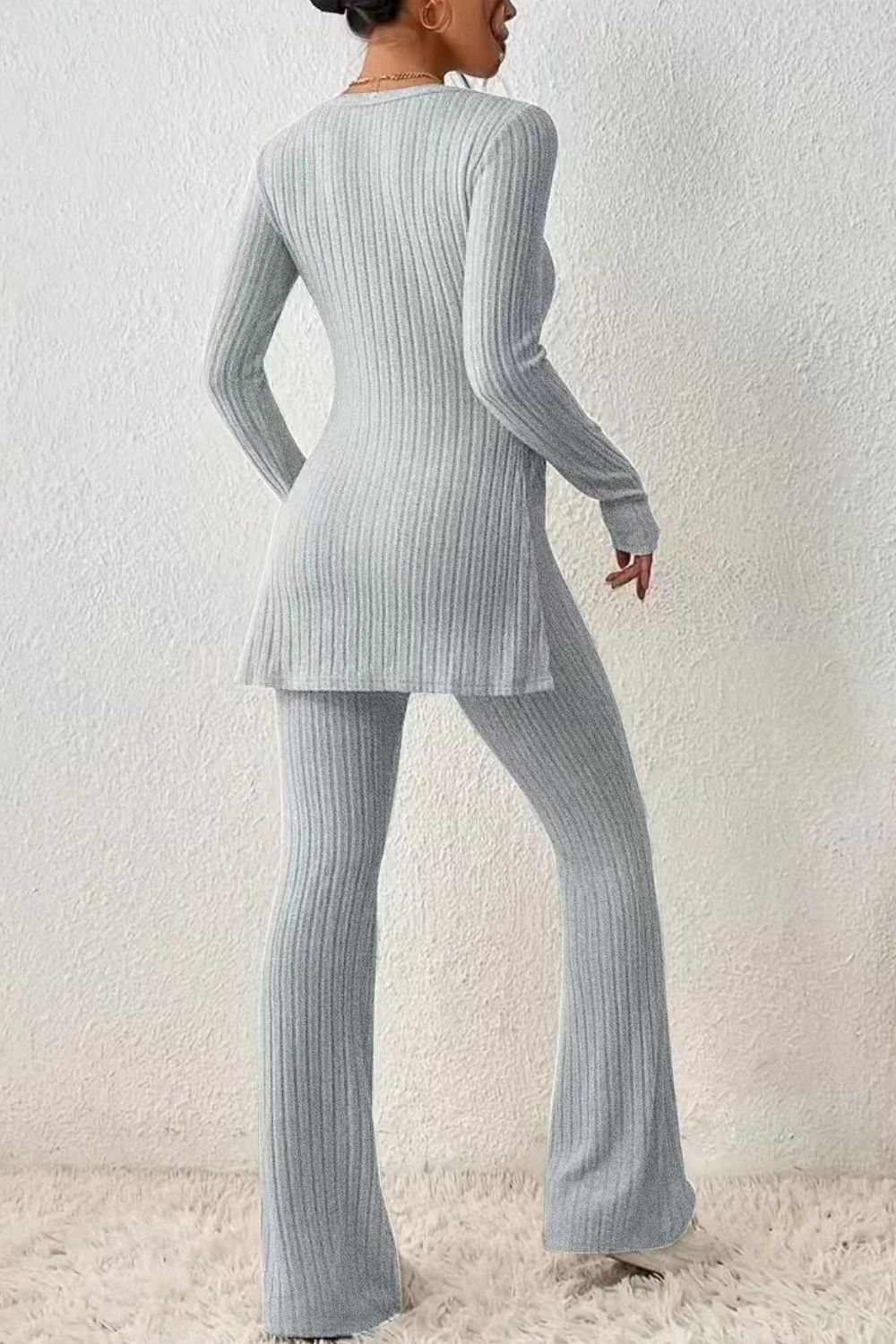 Light gray ribbed knit co-ord set with flared pants and tunic top with side slit.