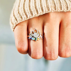 Sterling silver lotus ring with rainbow chakra stones and a pear-shaped center stone.
