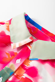 Pink abstract print blouse with ruffle front detail and contrasting collar.